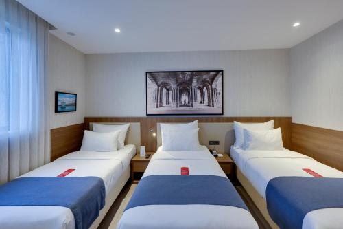 a hotel room with three beds in it at Ramada by Wyndham Istanbul Old City in Istanbul