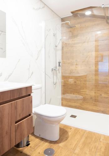 a bathroom with a white toilet and a shower at Quinta do Limite - Country House in Covilhã