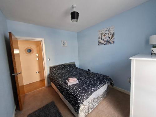 ein Schlafzimmer mit einem Bett mit einer schwarzen Bettdecke in der Unterkunft Two bedroom flat in Darlington in Darlington