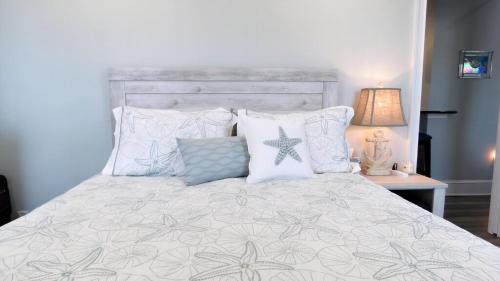 - une chambre avec un lit doté d'oreillers et d'une étoile de mer dans l'établissement The Belvedere Unit 2C, à Cape May