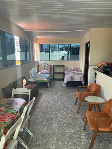 a room with two beds and a couch and chairs at Casa Alto da Sereia in Salvador