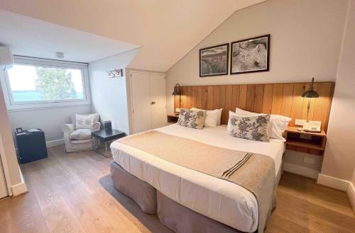 a bedroom with a large bed and a desk at La Cascada Casa Patagónica by DON in San Carlos de Bariloche
