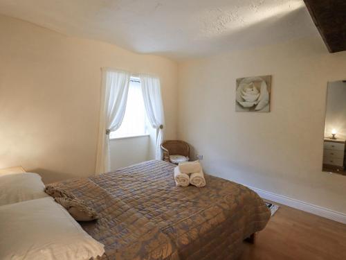a bedroom with a bed and a window at The Coach House in Wigton