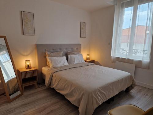 Un dormitorio con una cama grande con dos lámparas. en Bienvenue Au Margny Nest, en Margny-lès-Compiègne