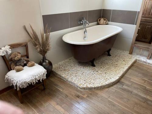 a bathroom with a large tub and a chair at Chambre retour en classe in Saint-Hilaire-des-Landes