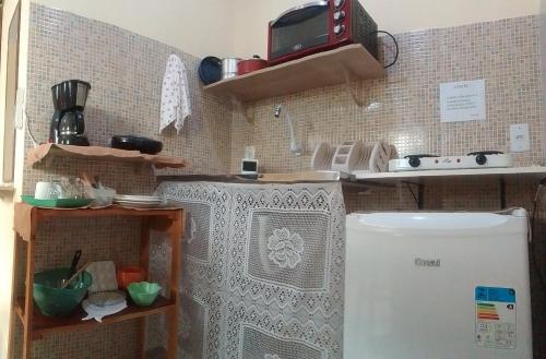 Flores do Riacho- Chalés في ساو ميغيل دوس ميلاجريس: مطبخ صغير مع ثلاجة في الغرفة