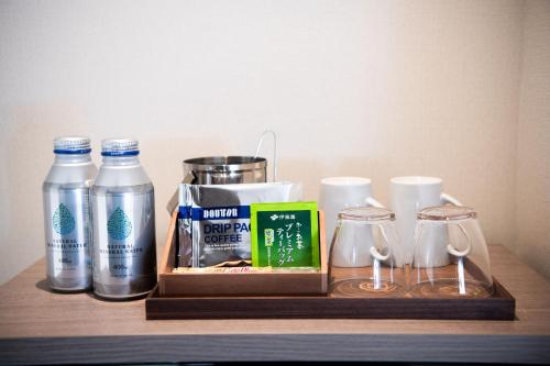 a wooden shelf with a bottle of water and two glasses at Hotel Emisia Tokyo Tachikawa in Tachikawa