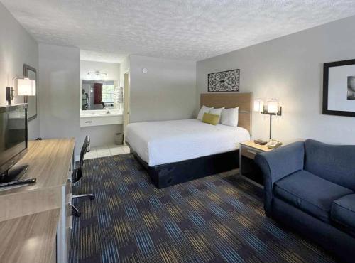 a hotel room with a bed and a couch at Mountain Aire Inn Sevierville - Pigeon Forge in Sevierville