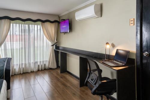 a room with a desk with a laptop on it at Hotel Rarinco in Los Ángeles