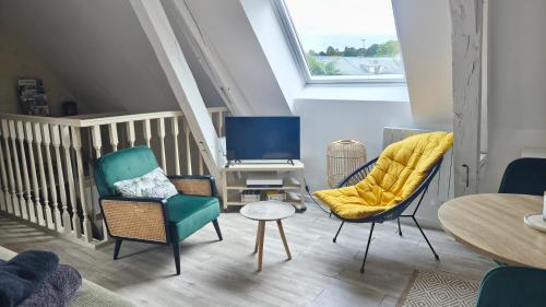a living room with two chairs and a table at Appartement cosy et calme, vue sur le château in Nogent-le-Rotrou