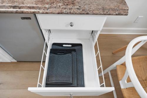 a cell phone in a drawer under a kitchen counter at Miramar Penthouse Coastal Elegance in the Heart of Half Moon Bay in Half Moon Bay