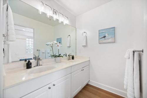 a white bathroom with a sink and a mirror at Miramar Penthouse Coastal Elegance in the Heart of Half Moon Bay in Half Moon Bay