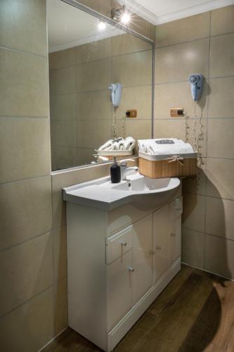 a bathroom with a sink and a mirror at Hotel Rarinco in Los Ángeles
