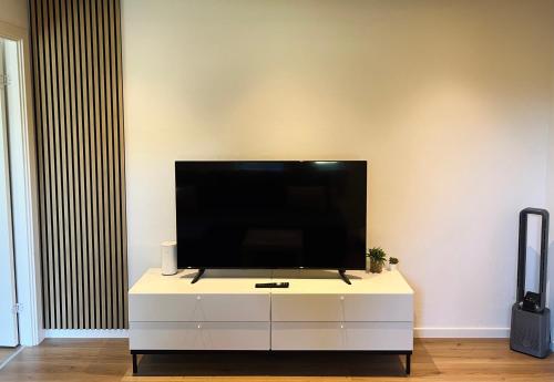 a flat screen tv sitting on top of a white cabinet at Lovely Billund Apartment by KIRIJA in Billund