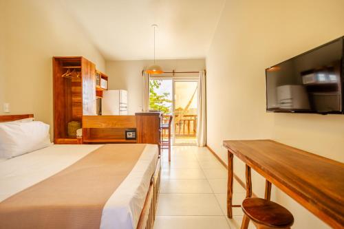a bedroom with a bed and a kitchen with a table at Villa das Palmeiras Jeri in Jericoacoara