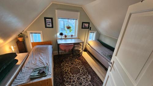 Dormitorio con letto, scrivania e finestra. di Large room, unique loftspartment, balcony, free parking ad Ålesund