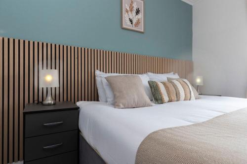 a bedroom with a large bed with a wooden headboard at Park House in Durham