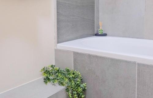 a white bath tub with a plant on the ledge at Prime Ridge in Midrand
