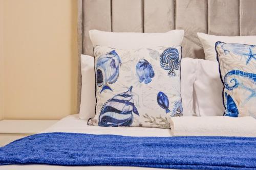 a bed with blue and white pillows on it at Prime Ridge in Midrand