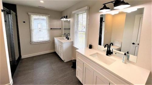 une salle de bain avec deux lavabos et un grand miroir dans l'établissement Sweet On Sunset! Brand New Construction!, à West Cape May