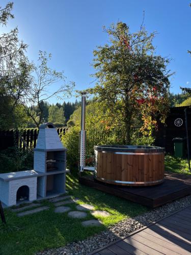 einen Whirlpool und einen Grill im Hof in der Unterkunft Domki na granicy in Jeżowski Dział