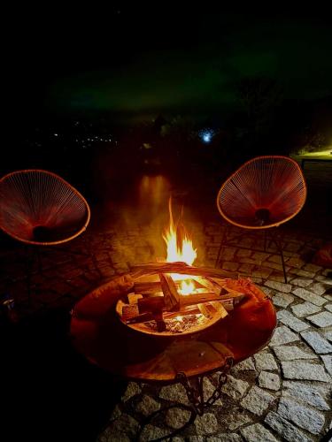 a fire pit with two chairs and a table at Casa 02 Monte Boa Vista - Casa de 4 Suítes com Vista Deslumbrante in Teresópolis
