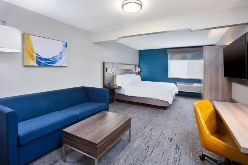 a hotel room with a couch and a bed at Holiday Inn Express Hotel & Suites Wauseon by IHG in Wauseon