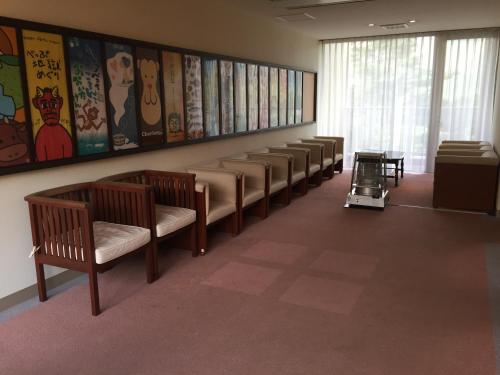 a waiting room with a row of benches and acart at hokkein-onsen kougen-terrace in Kokonoe