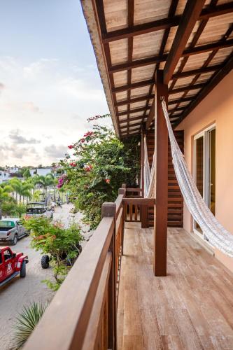 a balcony with hammocks and a view of a street at Villa das Palmeiras Jeri in Jericoacoara