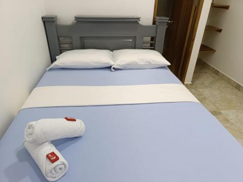 a bed with white sheets and towels on it at Hotel Panther Resort in Necoclí
