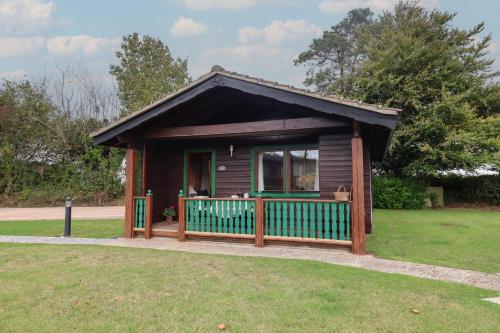 a small house with a porch in a yard at 10 Pinewood Retreat in Lyme Regis