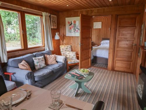 a living room with a couch and a bed at 10 Pinewood Retreat in Lyme Regis