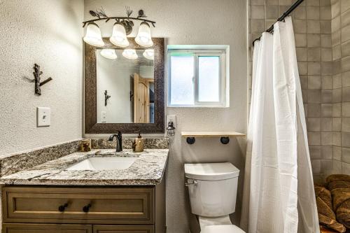 a bathroom with a sink and a toilet and a mirror at Ridgeway Adventure Haven 14 Mi to Ski Apache! in Sun Valley