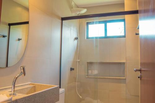 een badkamer met een douche met wastafel en spiegel bij Sol&coqueiros in Pôrto de Pedras