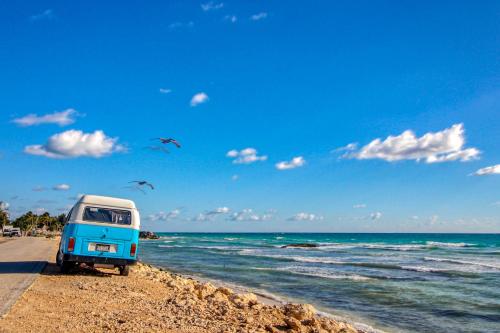 a blue van parked on a beach near the ocean at Moonlight 309 at Aldea Zama in Tulum