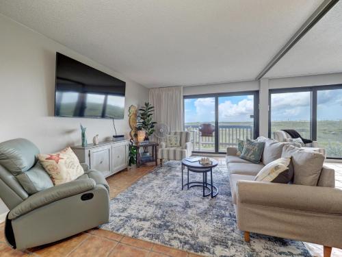 a living room with two couches and a table at Island House BeachFront Condo Hotel in Corpus Christi