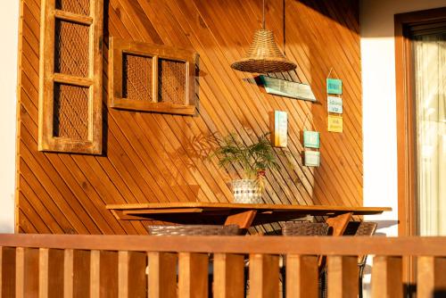 a wooden wall with a table and a potted plant at Refugio Na Praia Hospedagem - Guarda Do Embaú in Guarda do Embaú