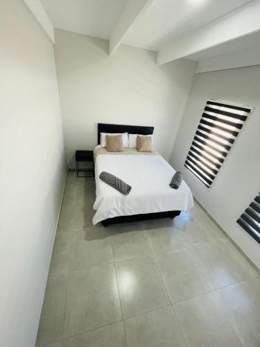 a bedroom with a bed in a white room at 44 Staycation Beach-house in Britannia Bay