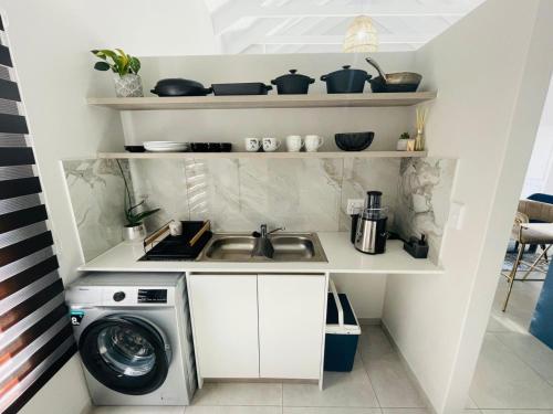 a kitchen with a sink and a washing machine at 44 Staycation Beach-house in Britannia Bay