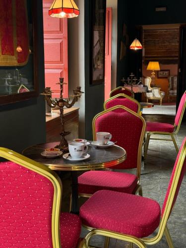 ein Esszimmer mit einem Tisch und Stühlen mit Tassen darauf in der Unterkunft Casa Emblemática Poggio Maldonado in Casa Nueva