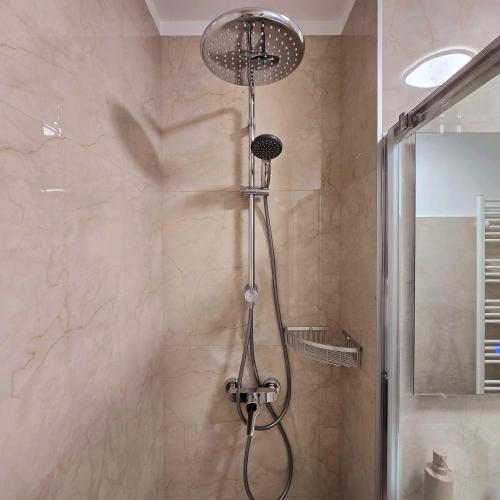 une douche avec pommeau de douche dans une salle de bain dans l'établissement Downtown Studio, à Râmnicu Vâlcea