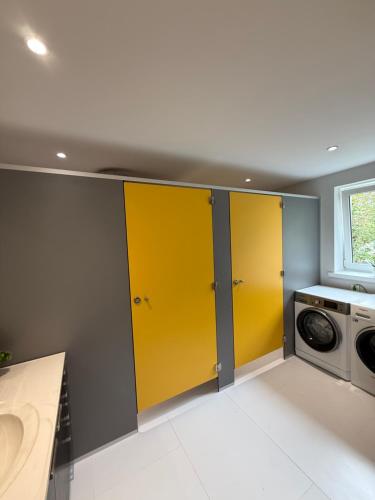 two yellow doors in a kitchen with a washing machine at Podkarpacka 50 in Rzeszów