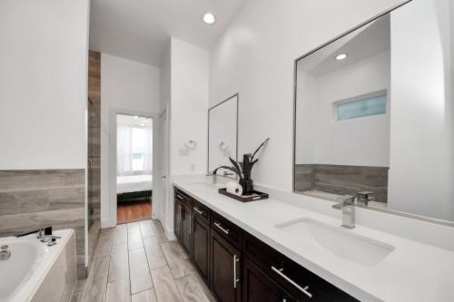 a bathroom with two sinks and a large mirror at Stylish Rooftop - East Downtown 3BR Near Everything in Houston