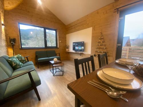 een woonkamer met een tafel en een eetkamer bij Chalet Iris, spa privatif, 4p in Rochesson