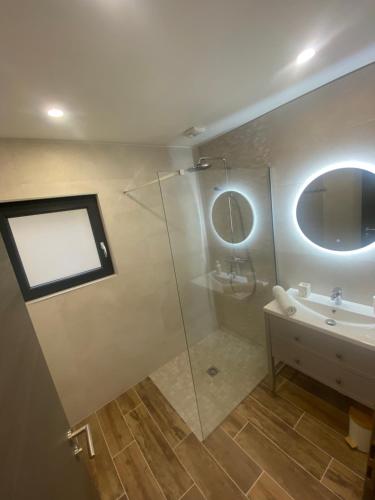 a bathroom with a shower and a sink and a mirror at Chalet iris & spa privatif in Rochesson