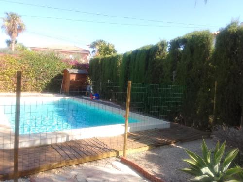 a fence around a swimming pool in a yard at Chalet Maria con Jardín Mediterráneo in San Juan de Alicante