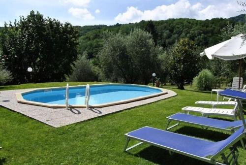 una piscina con tumbonas y sombrilla en il platano, en Monsagrati