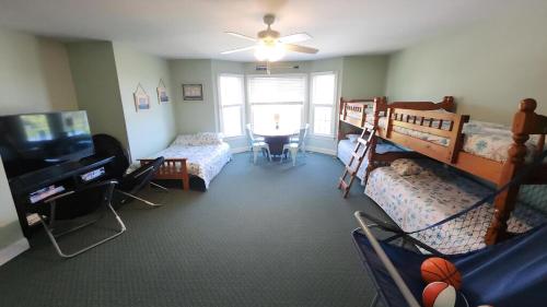 a bedroom with two bunk beds and a television at 1608 Maryland Henrys Hideaway in Cape May