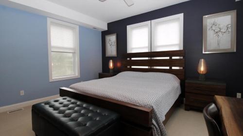 a bedroom with a bed and a chair and two windows at 516 Mistletoes In The Sand, Cape May Beach in Villas