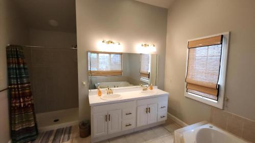 a bathroom with two sinks and a tub and a mirror at 1608 Maryland Henrys Hideaway in Cape May